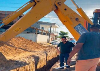 Prefeito de Itabela acompanha obra de drenagem e pavimentação com escavadeira em rua do município.
